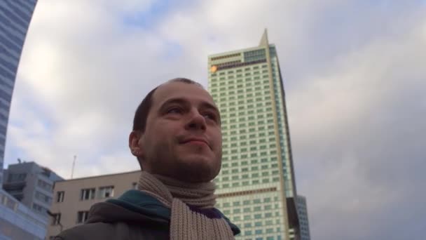 Молодой кавказский мужчина осматривается в деловом районе города. 4K steady icam video — стоковое видео