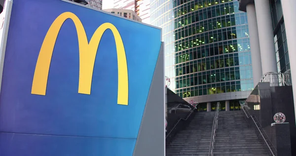 Tablero de señalización con el logotipo de McDonalds. Rascacielos moderno centro de oficina y escaleras de fondo. Representación Editorial 3D —  Fotos de Stock