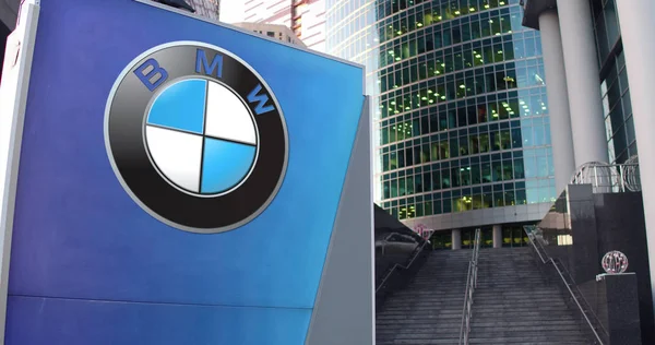 Tablero de señalización de calle con logotipo de BMW. Rascacielos moderno centro de oficina y escaleras de fondo. Representación Editorial 3D —  Fotos de Stock