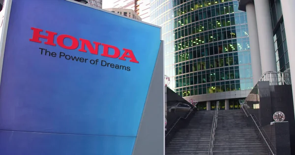 Straat signalisatie bord met Honda logo. Moderne kantoor centrum wolkenkrabber en trappen achtergrond. Redactioneel 3D-rendering — Stockfoto