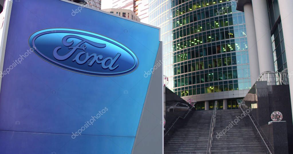 Street signage board with Ford Motor Company logo. Modern office center skyscraper and stairs background. Editorial 3D rendering United States
