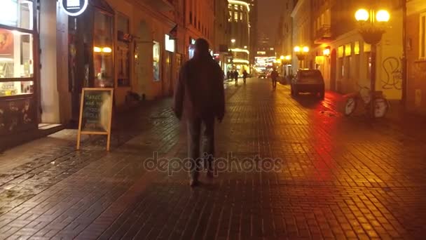 WARSAW, POLONIA - 28 DE NOVIEMBRE DE 2016. La gente camina por la calle del casco antiguo en la noche nevada. Ciudad europea 4K steadicam video — Vídeo de stock