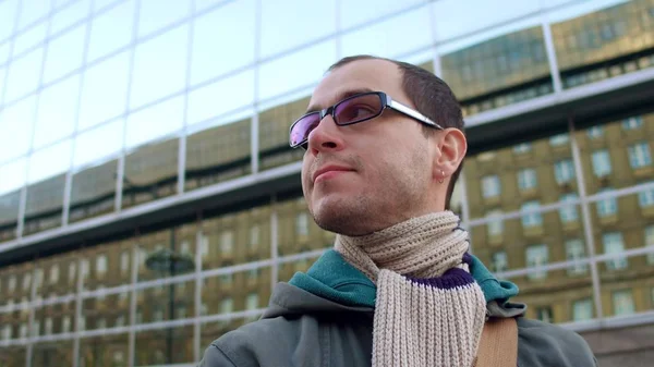 Intelligent man wearing black rim glasses looks around in city business district — Stock Photo, Image