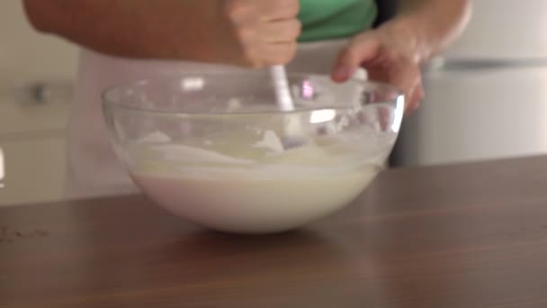 Man stirring dough in a glass bowl. Steadicam slow motion shot — Stock Video