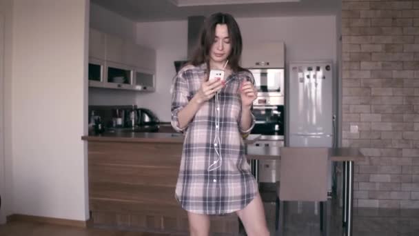 Uma jovem bonita de camisa xadrez a dançar em casa. Steadicam 4K tiro — Vídeo de Stock
