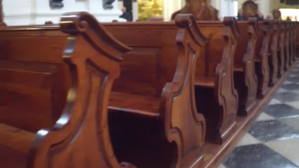 Rangées de bancs en bois dans l'église catholique. Vidéo 4K steadicam — Video