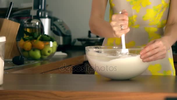 Женщина, помешивающая тесто в стеклянную миску. Скоростной выстрел Steadicam — стоковое видео