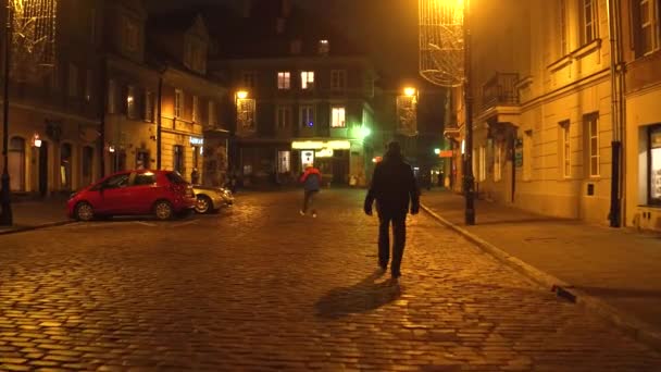 WARSAW, POLONIA - 28 DE NOVIEMBRE DE 2016. Acogedora calle del casco antiguo por la noche. Ciudad europea 4K steadicam video — Vídeos de Stock