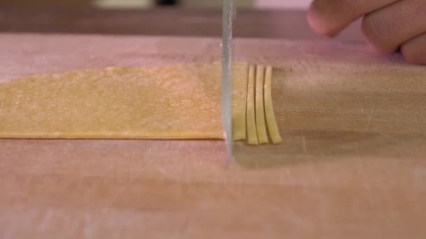 Couper des pâtes maison avec un couteau. Cuisine amateur à la maison. 4K steadicam gros plan — Video