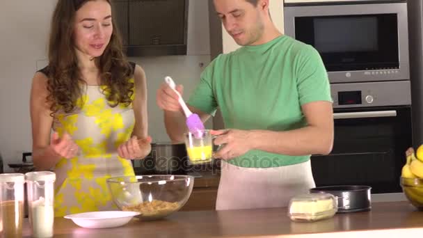 Mann und Frau kochen zu Hause gemeinsam Dessert. 4k Steadicam-Video — Stockvideo