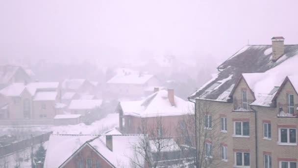 Super cámara lenta de tormenta de nieve sobre techos inclinados de casas residenciales en invierno — Vídeos de Stock