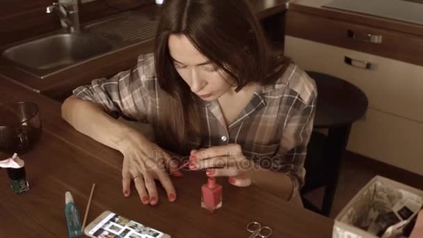 美しいブルネットの女性は、自分の自宅でマニキュアを与えます。4 k ステディカム動画 — ストック動画