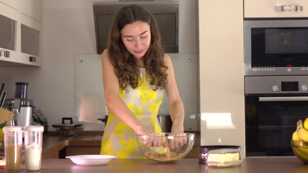 Schöne junge Frau, die zu Hause Dessert zubereitet. 4k Steadicam-Video — Stockvideo