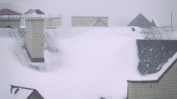 Super slow motion video van sneeuwstorm boven residentiële huizen in de winter — Stockvideo