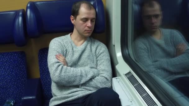 Tired man in sweater sleeping in his seat in a train. 4K video — Stock Video