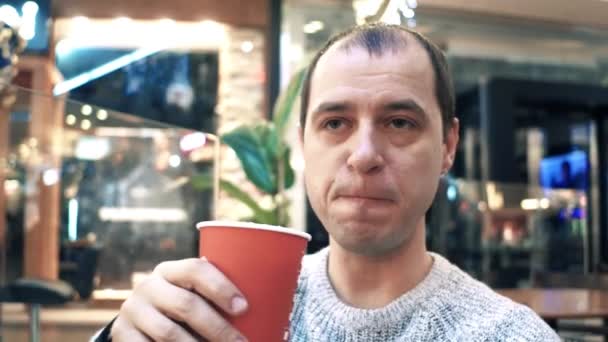 Nachdenklicher Mann, der in einem Café eine große Tasse Kaffee aus Einwegpapier hat. 4k-Video — Stockvideo
