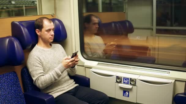 電車の中の彼の携帯電話のメールを入力する深刻な白人男。現代の無線通信技術。4 k ビデオ — ストック動画