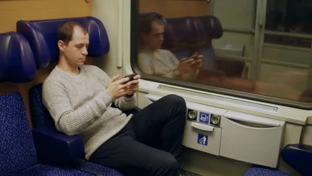 Homme regardant un film dans son smartphone dans un train. Vidéo 4K — Video