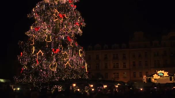 Praga, Republika Czeska - 3 grudnia 2016. 4 k strzał zatłoczone miasto turystyczne, kwadrat i duże ozdobione choinki w nocy — Wideo stockowe