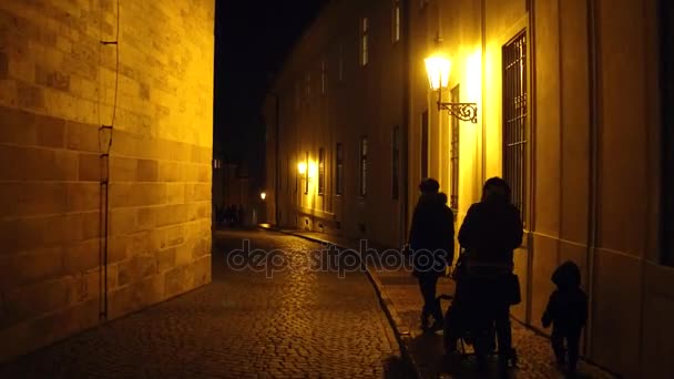 Silhouetten einer Familie, die nachts in der Prager Altstadt spazieren geht. 4k Steadicam-Video — Stockvideo