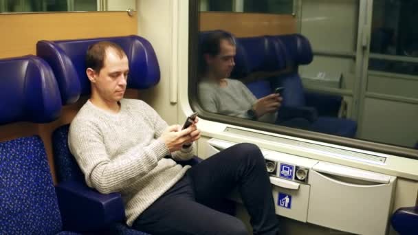 Uomo digitando e scorrendo app nel suo telefono cellulare in un treno. Moderne tecnologie di comunicazione wireless. Video 4K — Video Stock