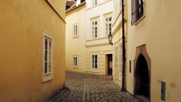 布拉格，捷克共和国-2016 年 12 月 3 日。4 k 替身拍摄的狭窄的鹅卵石铺成的空荡荡的街道。老欧洲小镇风景 — 图库视频影像
