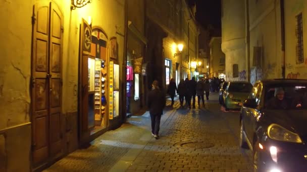 PRAGA, REPÚBLICA CHECA - 3 DE DICIEMBRE DE 2016. Steadicam tiro de turistas caminando en la calle de la noche. Vídeo 4K — Vídeos de Stock