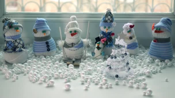 Toy handmade snowmen on a windowsill and snowstorm outside the window. 4K tilt shot — Stock Video