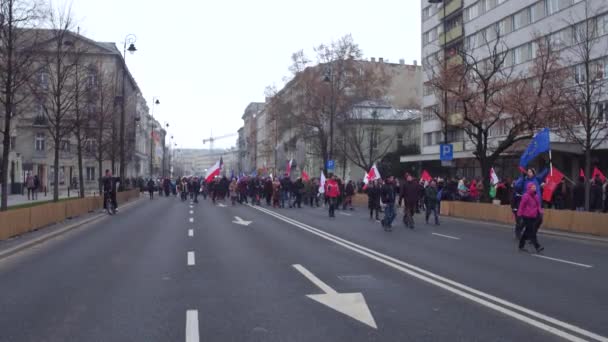 WARSAW, POLOGNE - 17 DÉCEMBRE 2016. Manifestants avec des drapeaux polonais et européens marchant dans la rue. Plan panoramique 4K — Video