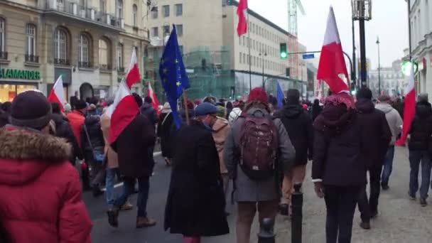 Varšava, Polsko - 17 Prosinec 2016. Dav s polskými a Eu vlajky, pochodující na ulici. 4 k steadicam shot — Stock video