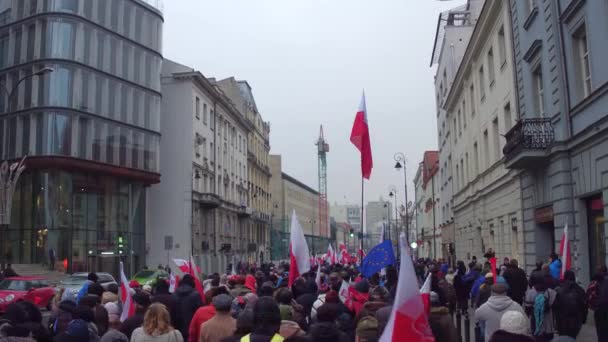 WARSAW, POLOGNE - 17 DÉCEMBRE 2016. Des gens avec des drapeaux polonais et européens défilant dans la rue. 4K steadicam shot — Video