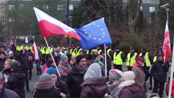 WARSAW, POLONIA - 17 DE DICIEMBRE DE 2016. Personas con banderas polacas y de la UE atadas en la calle. 4K pan video — Vídeo de stock