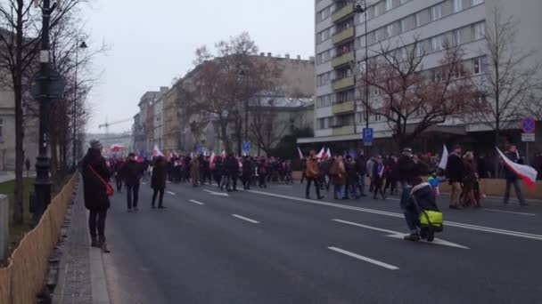 WARSAW, POLOGNE - 17 DÉCEMBRE 2016. Des gens avec des drapeaux polonais et européens défilant dans la rue. Plan panoramique 4K — Video