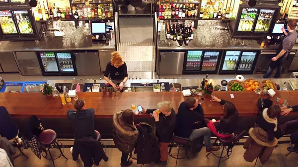 WARSAW, POLAND - DECEMBER, 21, 2016. People drinking and hanging out at the bar. Top shot — Stock Photo, Image