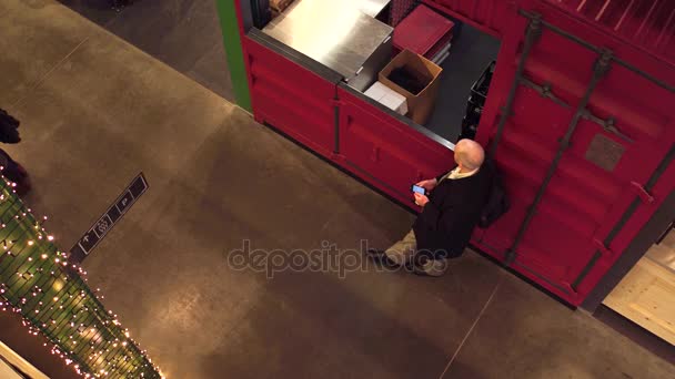 GARANTIA, POLÓNIA - 21 DE DEZEMBRO DE 2016. Homem careca esperando e rolando seu telefone celular. 4K vista de cima tiro — Vídeo de Stock
