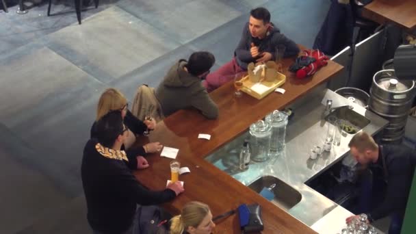 WARSAW, POLONIA - 22 de diciembre de 2016. Jóvenes tomando bebidas. Pasando el rato en el bar. Vídeo superior 4K — Vídeo de stock