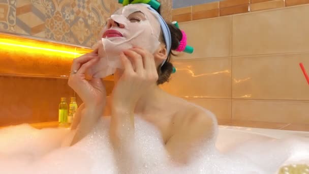 Za pomocą maseczka do twarzy w kąpieli spieniony brunetka kobieta. Zabiegi kosmetyczne w domu. wideo 4k — Wideo stockowe