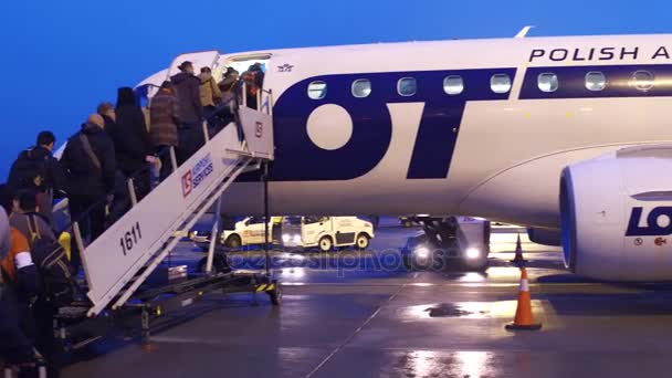 Warszawa, Polen - människor 23 December, ombordstigning hel airlines plan på flygfältet på natten. 4 k pan video — Stockvideo