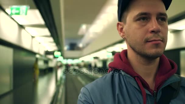Kaukázusi ember visel sapkát használja travelator a reptéri terminálnál. 4k videóinak — Stock videók
