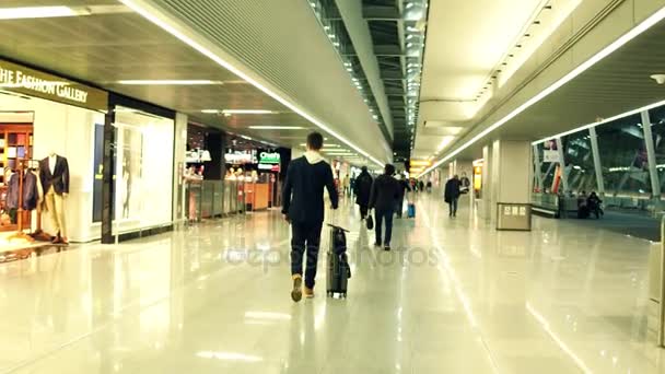 Varšava, Polsko – 24. prosince, Steadicam záběr mužské cestujících na mezinárodním letišti terminálu u dutyfree úložiště. 4k video — Stock video