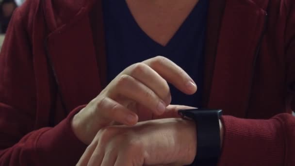 Человек в красных кранах на своих умных часах. Современное носимое устройство. 4K видео крупным планом — стоковое видео