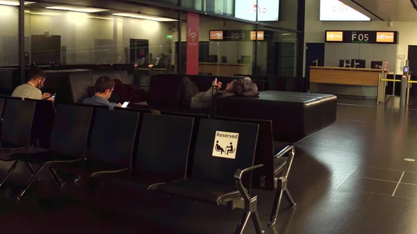 Warsaw, Polen - 24 December, passagiers op de luchthaven terminal vertreklounge. Gereserveerde plaatsen voor zwangere vrouwen en senioren — Stockfoto