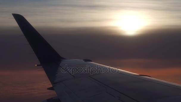 Borda da asa do avião contra o pôr-do-sol nublado. 4k vídeo aéreo — Vídeo de Stock