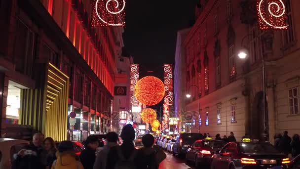 Vídeň, Rakousko - 24. prosince, Steadicam záběr Vánoc zařízené turistické ulici večer. Krásné sváteční iluminace. 4 k klip — Stock video