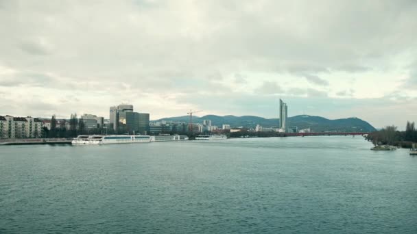 ВЕНА, Австрия - 25 DECEMBER Steadicam снимок реки Дунай, туристические лодки и далекий Pensionsversicherungsanstalt офиса. 4K видео — стоковое видео