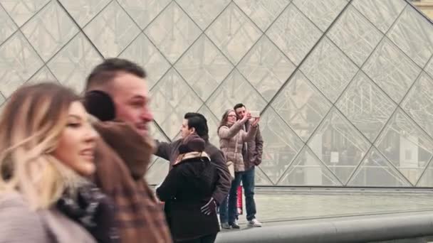 Paris, Frankrijk - 31 December. Steadicam schot van paren selfies in de buurt van het Louvre glazen piramide die was, de beroemde Franse museum en de populaire toeristische bestemming maken. 4k video — Stockvideo