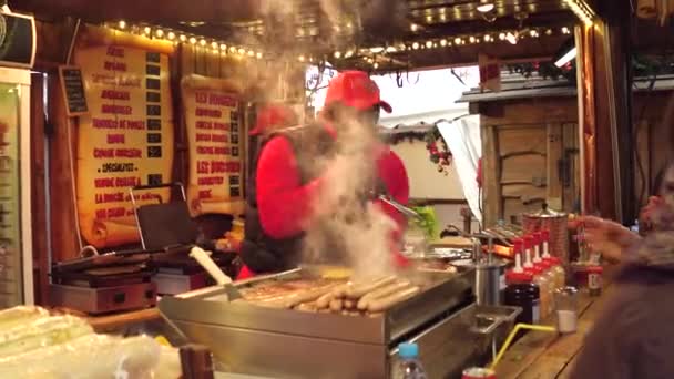 Παρίσι, Γαλλία - 31 Δεκεμβρίου. Χριστούγεννα και νέο έτος αγοράς fastfood στάβλο προμηθευτές στην εργασία. Μαύρο και καυκάσιος άνδρες μαγείρεμα burgers και σάντουιτς. βίντεο 4k — Αρχείο Βίντεο