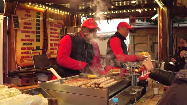 PARIS, FRANÇA - DEZEMBRO, 31. Natal e Ano Novo mercado fast food stall vendedores no trabalho. Homens negros e caucasianos cozinhando hambúrgueres e sanduíches. 4K tiro — Vídeo de Stock