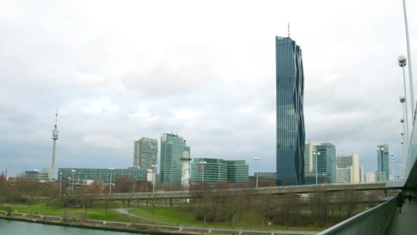 VIENA, AUSTRIA - 25 DE DICIEMBRE DE 2016 Steadicam toma de la orilla del río que involucra a la Torre del Danubio, el rascacielos de Donau City y el Centro Internacional, lugar de la Organización de las Naciones Unidas. Vídeo 4K — Vídeo de stock