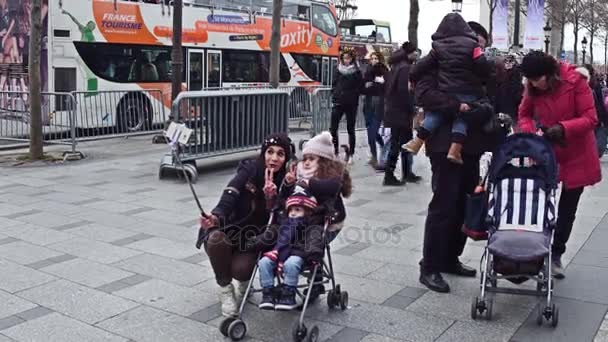 Paris, Francja - 31 grudnia 2016 roku. Wesoły matki i jej dzieci podejmowania selfie na słynnej francuskiej ulicy Champs-Elysees. Popularna miejscowość turystyczna. wideo 4k — Wideo stockowe